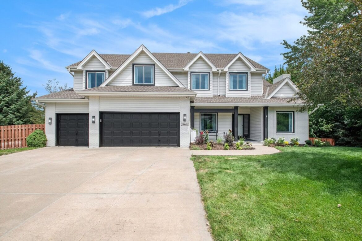 White single family home with black garage doors and large driveway.jpg