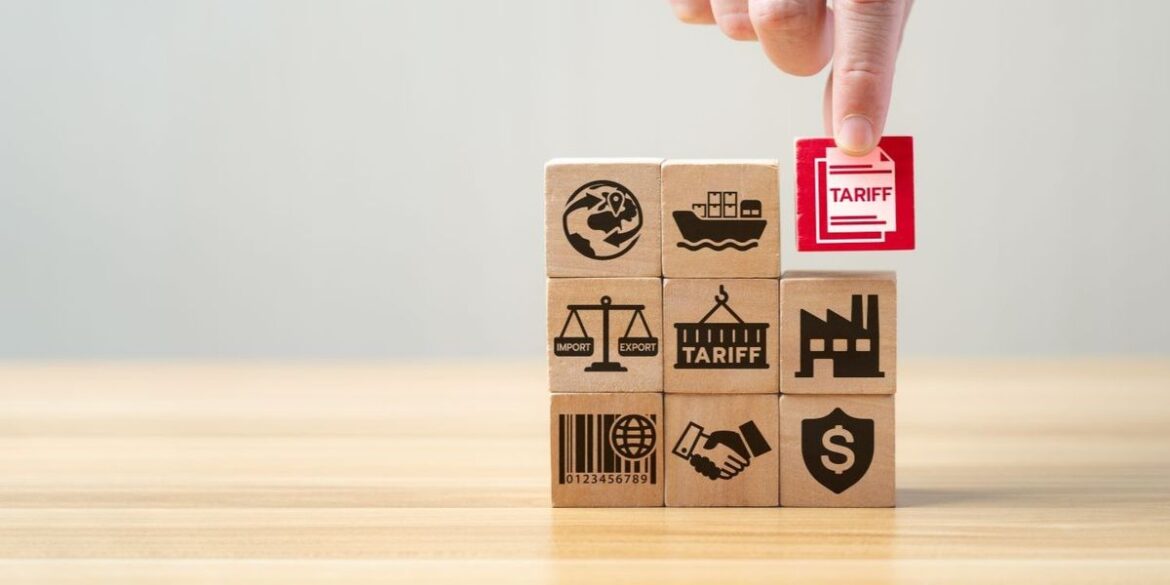 Hand placing a red tariff block on stacked wooden trade blocks.jpg