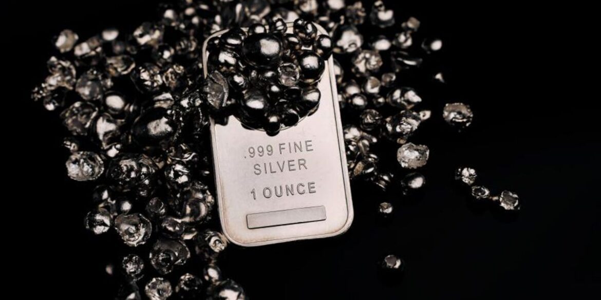 Silver bar surrounded by shiny silver nuggets on a black background.jpg
