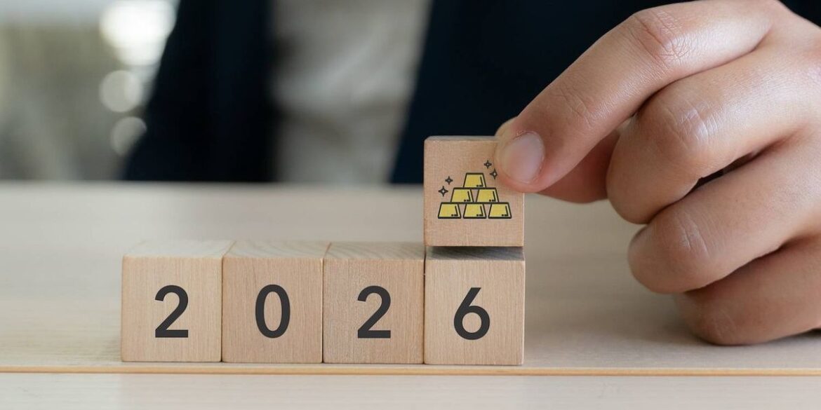 Wooden blocks showing a picture of gold bars and the year 2026.jpg