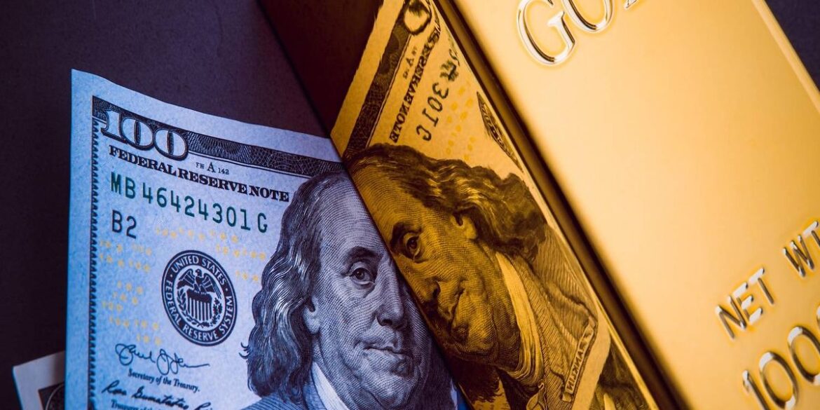 Us 100 bill lies over a gold bar.jpg