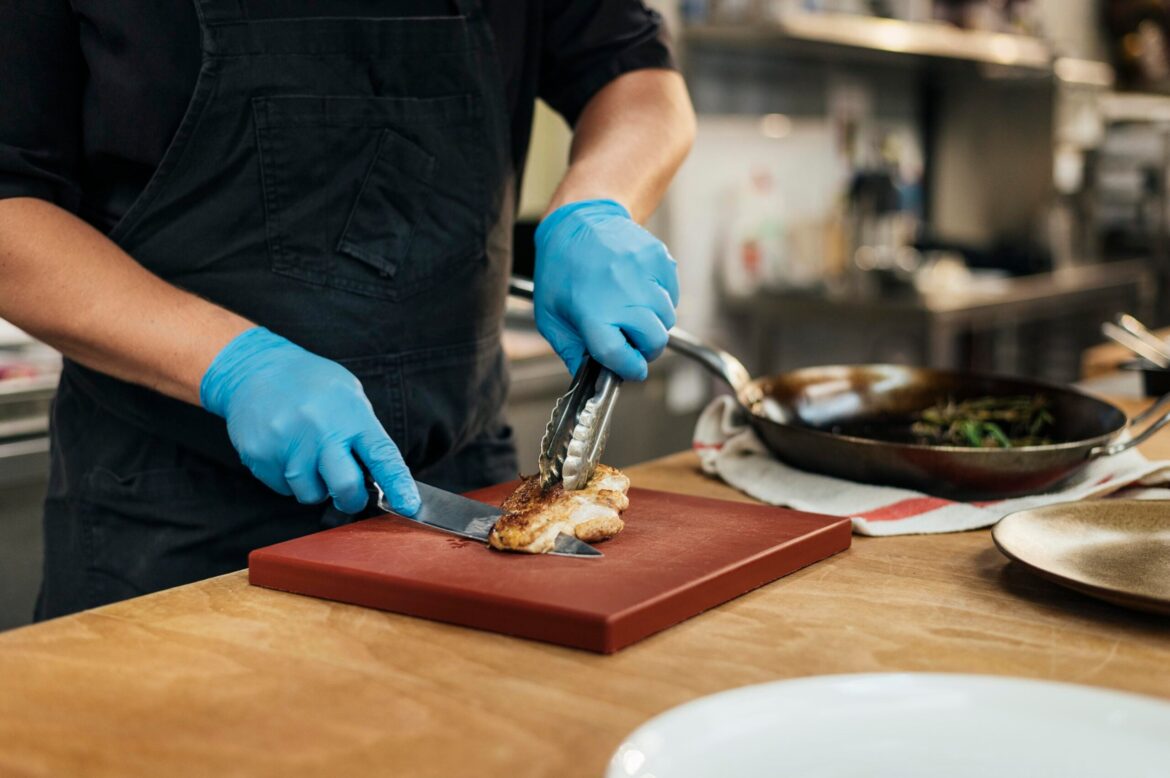 Male chef with gloves chopping meat scaled.jpg