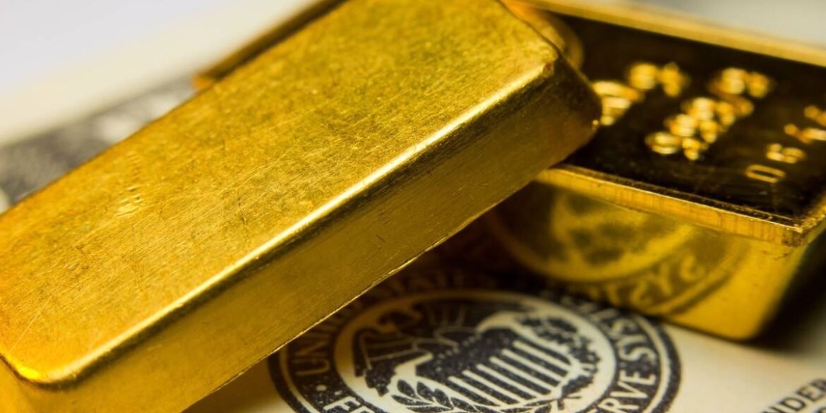Gold bars resting on a federal reserve document with emblem and partial visible text.jpg