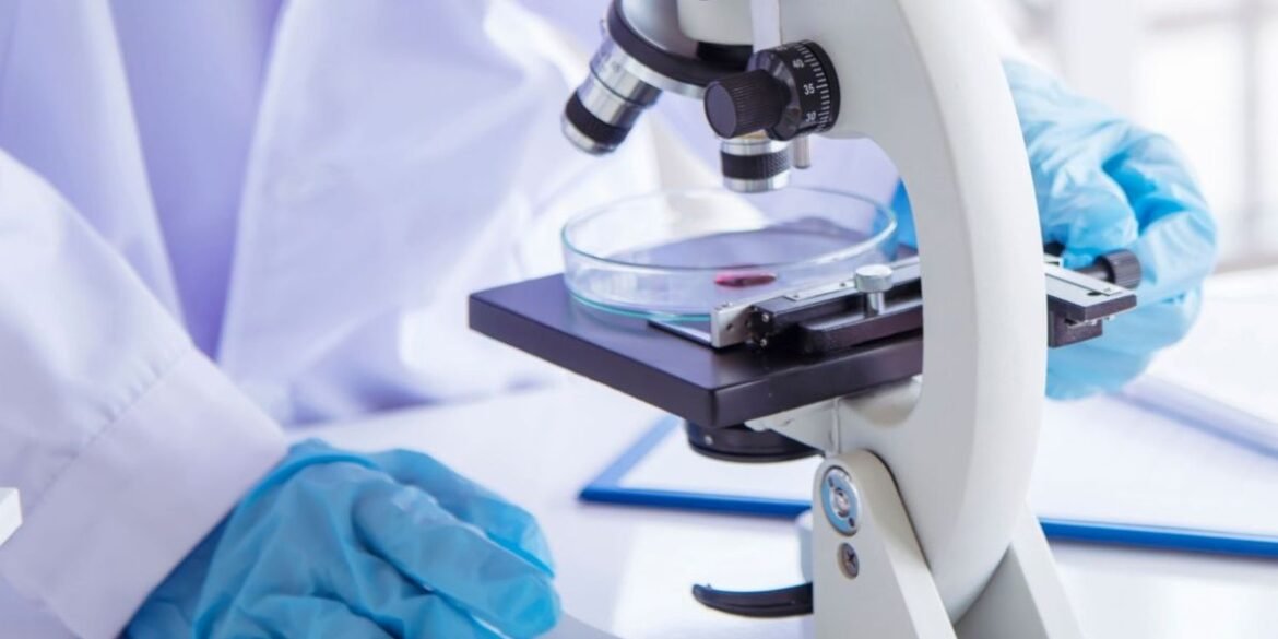 Researcher in medical lab looking at sample with microscope.jpg