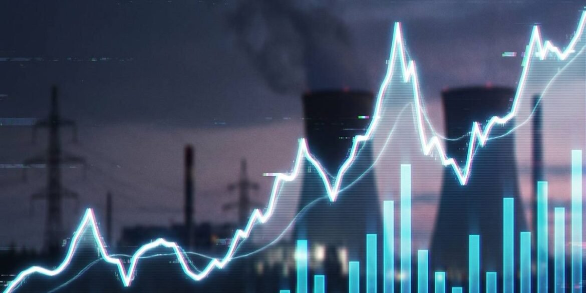 Glowing line graph overlays power plant with cooling towers and smokestacks against a moody sky.jpg